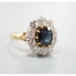 A modern 18ct gold, sapphire and diamond set oval cluster ring, size P/Q, gross weight 6.2 grams.