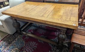 An 18th century style pale oak draw leaf dining table on carved baluster legs, length 242cm