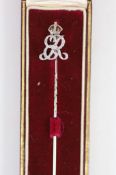 A white gold stick pin with diamond and red enamel monogram ‘’ER’’, beneath a crown, in