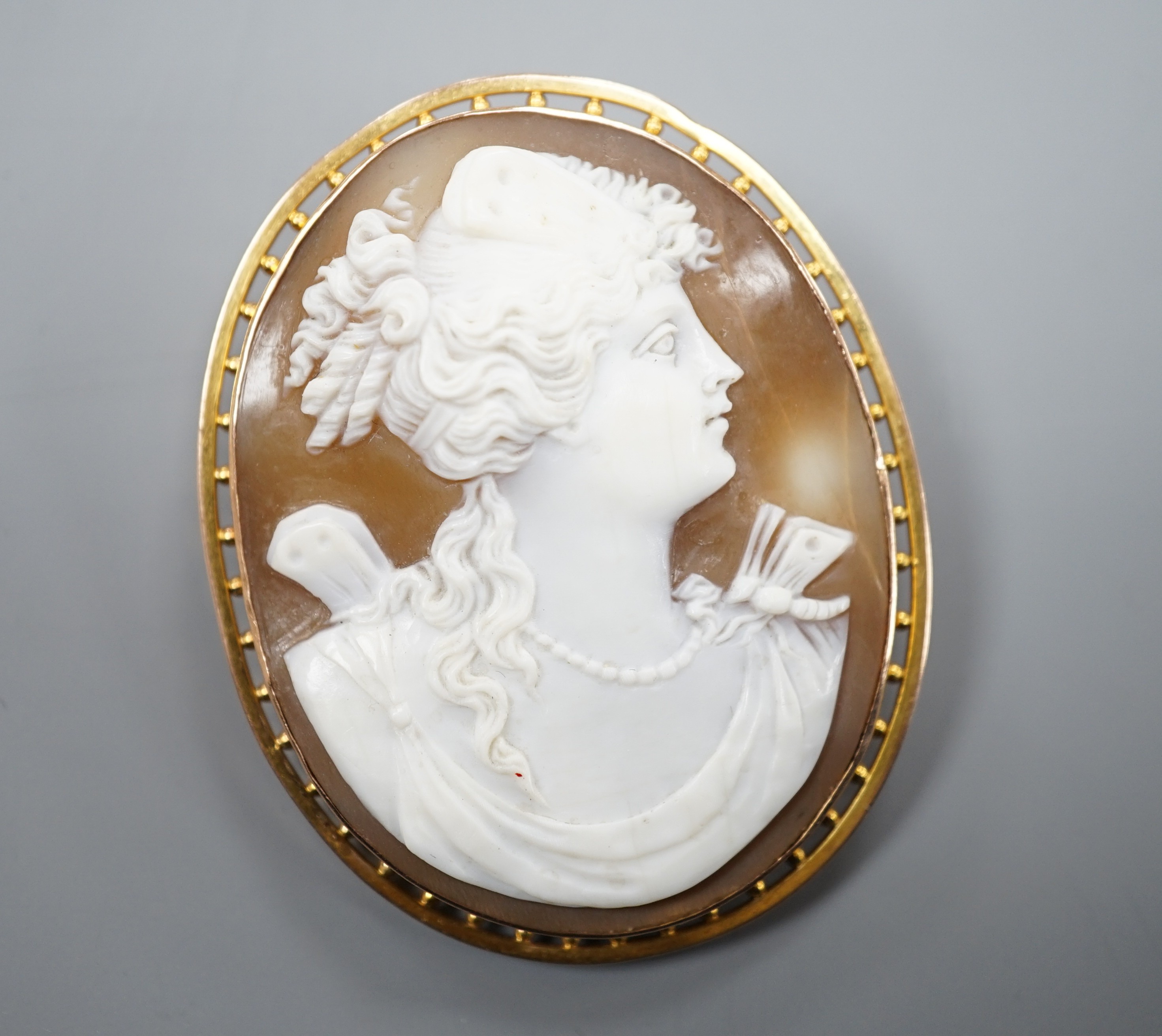 A 9ct mounted oval cameo shell brooch, carved with the bust of a lady to sinister, 5cm, gross weight