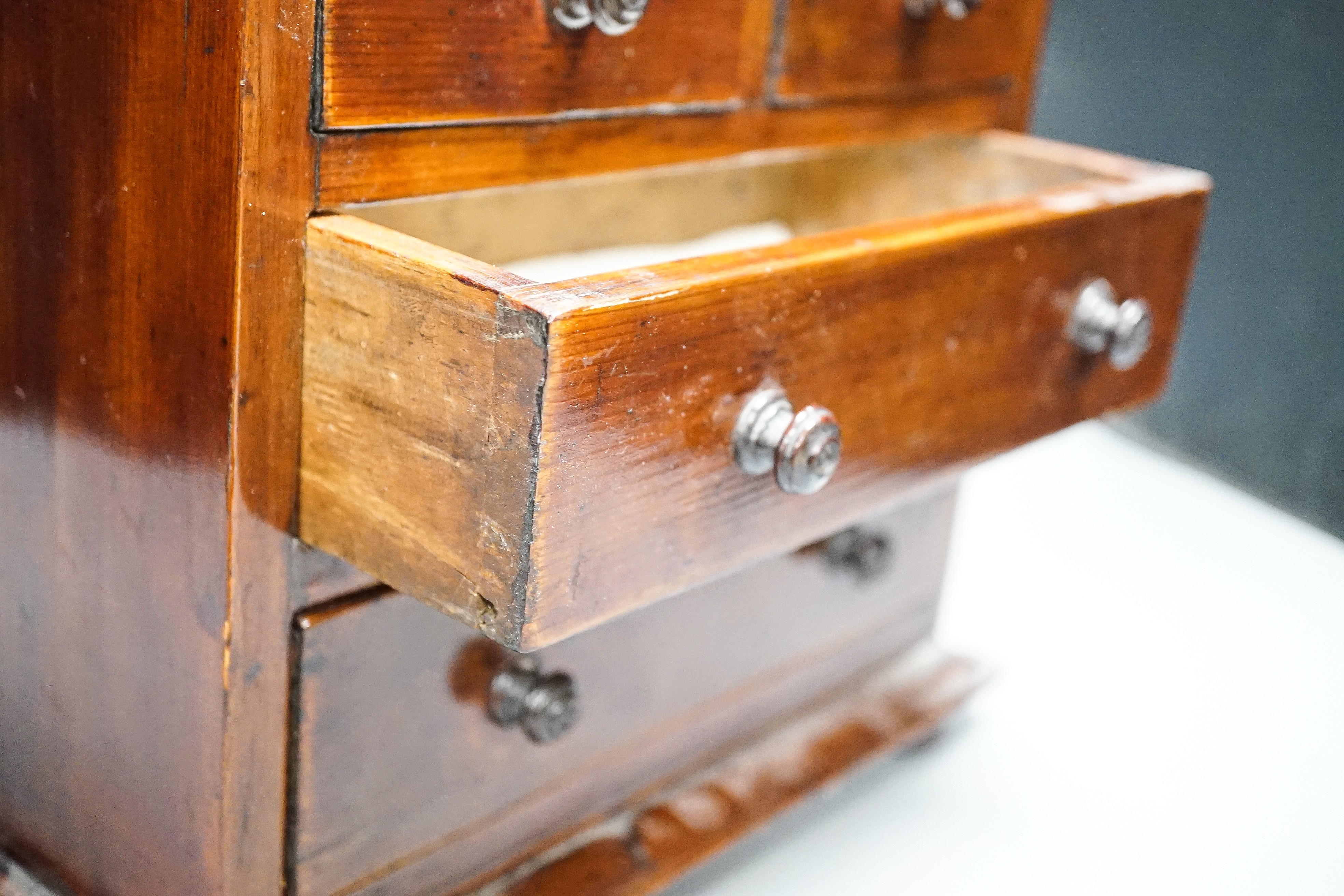 A Victorian stained pine miniature chest of drawers, 27 cms high. - Image 4 of 5