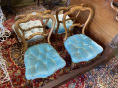 A set of four Victorian walnut balloon back upholstered dining chairs