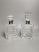 A pair of silver mounted cut glass decanters, with mis-matched stoppers