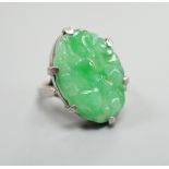 A white metal and oval jade set ring, carved with fruit, size F, gross weight 6.3 grams.