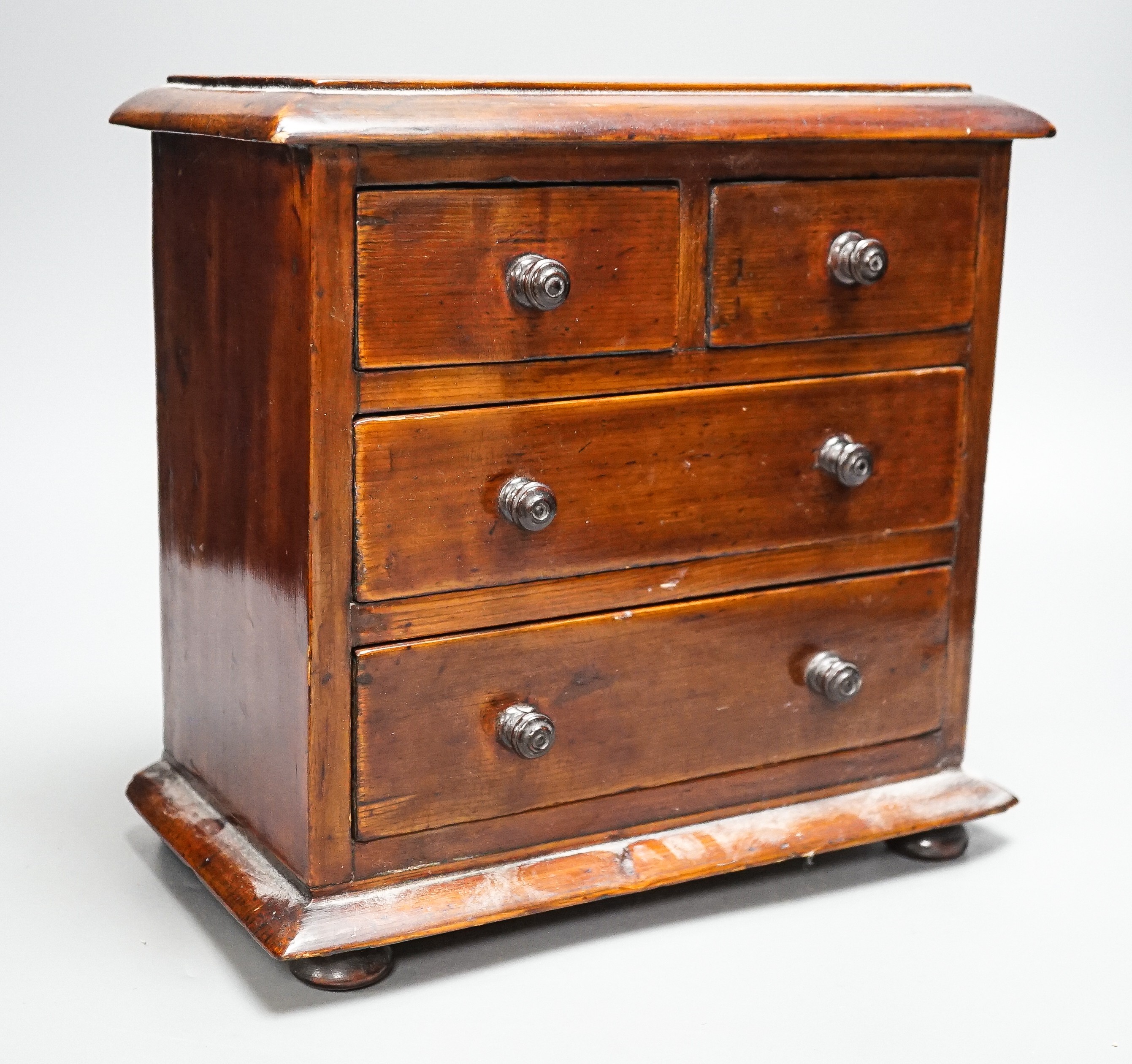 A Victorian stained pine miniature chest of drawers, 27 cms high. - Image 3 of 5