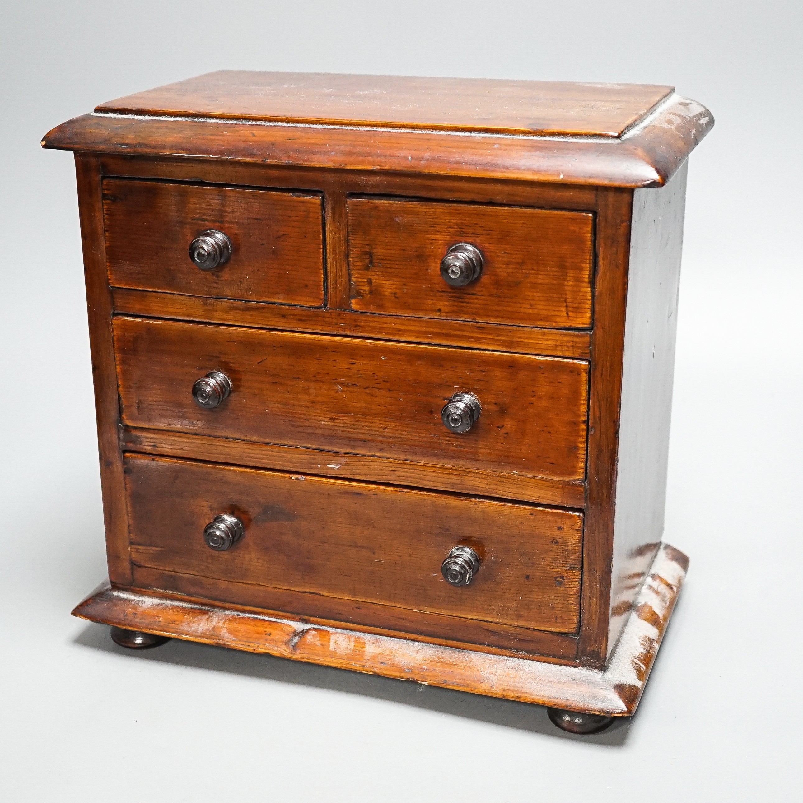 A Victorian stained pine miniature chest of drawers, 27 cms high. - Image 2 of 5