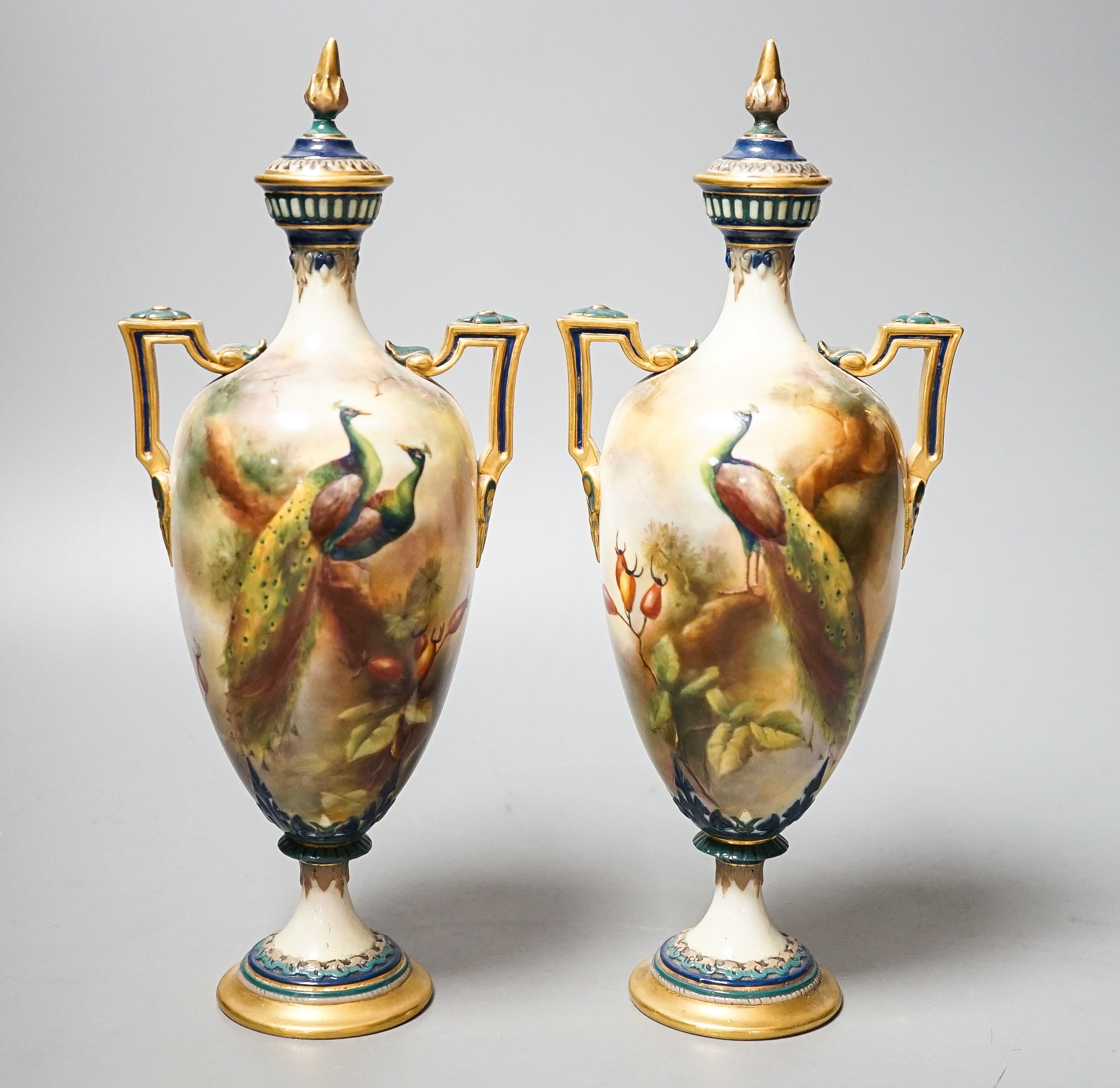 A pair of Royal Worcester Hadley ware Peacock vases and covers 24cm