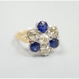 A modern 18ct gold, four stone diamond and three stone sapphire set flower head cluster ring, size