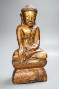 A Burmese gilded carved wooden figure of Buddha, 35 cms high.