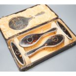 A 1920's cased tortoiseshell and silver mounted mirror and brush set.