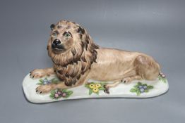 A Meissen style porcelain recumbent lion, 30 cms wide.
