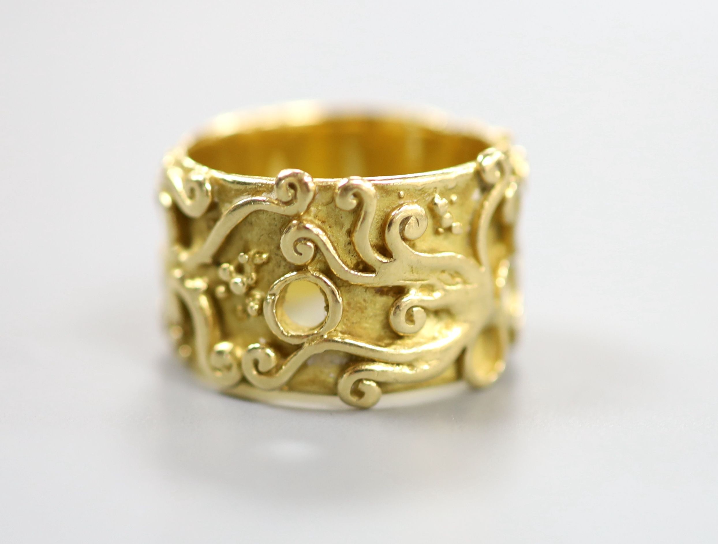 An 18ct Welsh gold band, with pierced and scroll decoration, size O, 11.8 grams.