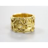 An 18ct Welsh gold band, with pierced and scroll decoration, size O, 11.8 grams.