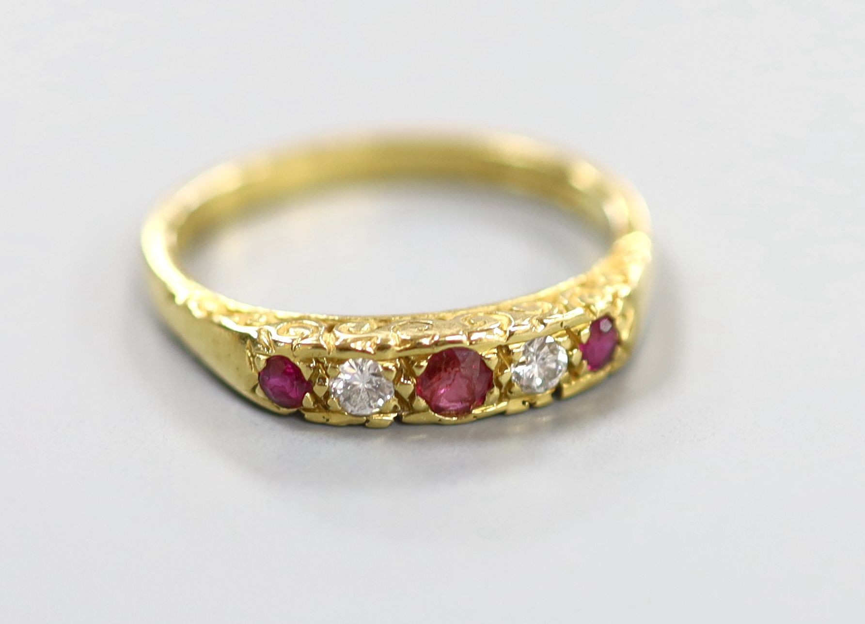 A modern 18ct gold, two stone diamond and three stone ruby half hoop ring, size O, gross weight 3.