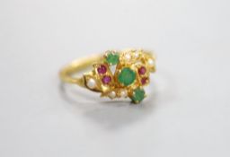 A modern yellow metal, emerald, ruby and seed pearl cluster set crossover ring, size L, gross weight