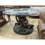 A bronzed composition glass top figures table. Diameter - 122cm, Height - 76cm.