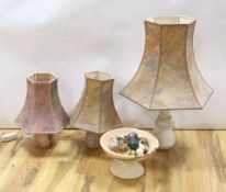 A collection polished stone eggs, dishes and three table lamps and shades.