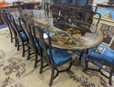 A Chinese lacquer decorated dining table and 12 chairs. Length -277cm, Depth- 120cm, Height - 74cm.