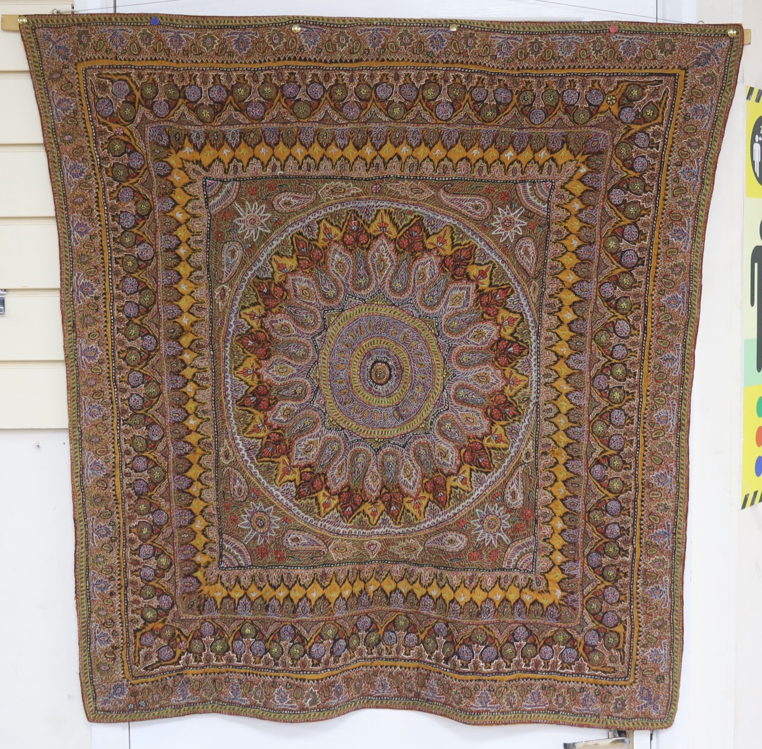 A Kashmiri wool embroidered hanging, with central cartouche,, 97 cms wide x 99 cms high.