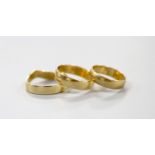 Two 9ct gold wedding bands, 4.7 grams and one other shaped yellow metal band, 3.3 grams.