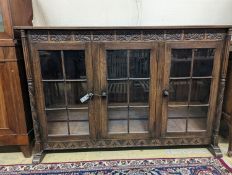 A 17th century style oak glazed low bookshelf. W-152cm, D-38cm, H-100cm.