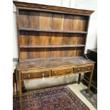 A George III oak dresser, with two shelf rack and three long drawers, on chamfered legs, width