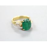 A yellow metal, emerald and diamond three stone ring, size M, gross weight 5.3 grams.