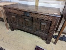 A 17th century carved oak coffer. W-124cm, D-56cm, H-72cm.