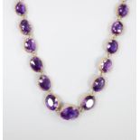 A late Victorian yellow metal and graduated oval cut amethyst set necklace, 39cm, gross weight 37