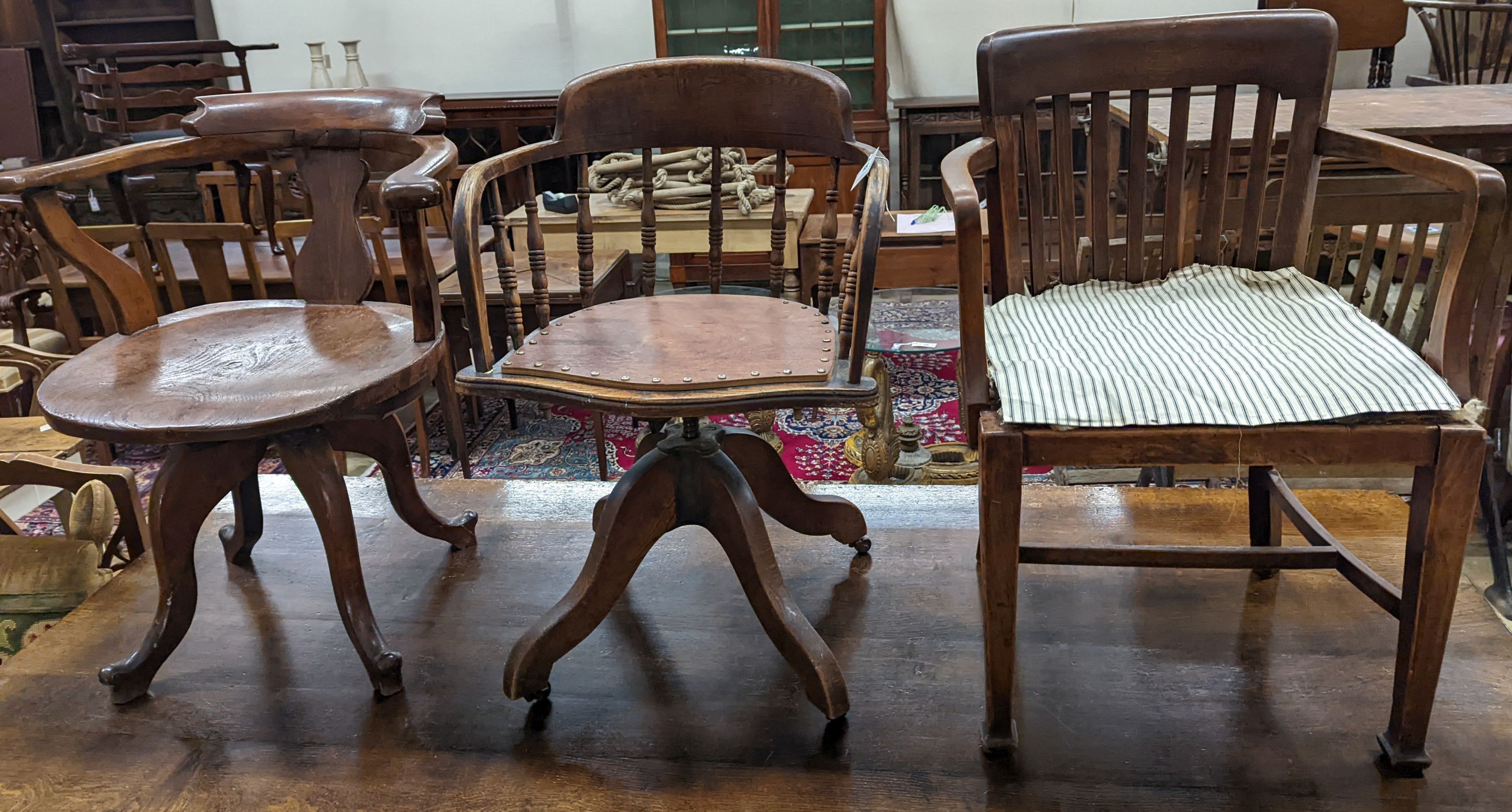 Two early 20th century swivel desk chairs and another chair.