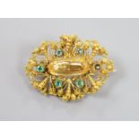 An early 20th century filigree yellow meta, emerald and citrine set oval brooch (emerald missing),