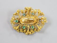 An early 20th century filigree yellow meta, emerald and citrine set oval brooch (emerald missing),