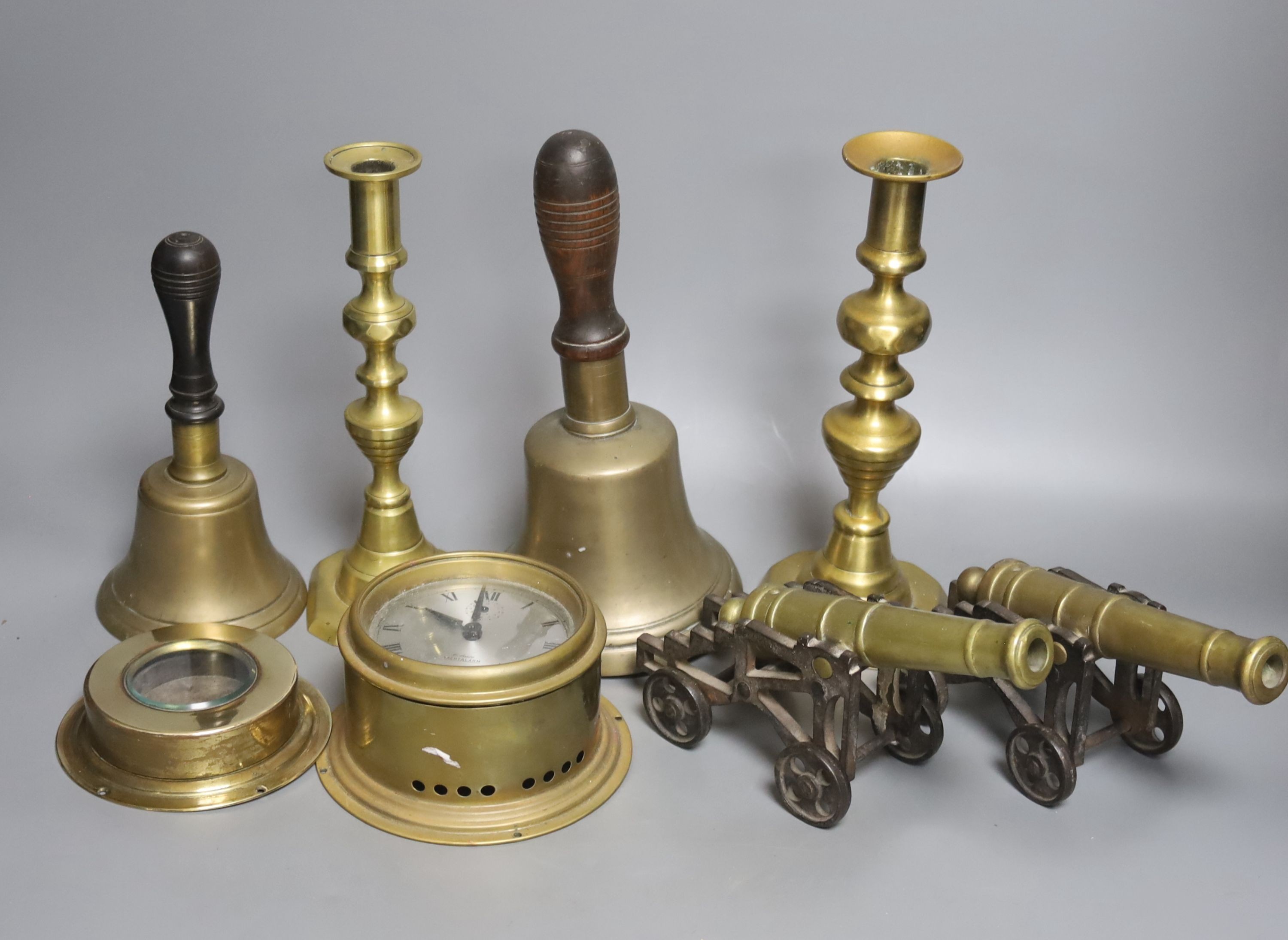 A quantity of brassware including bells, model cannons, candlesticks etc.