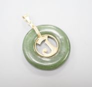 A yellow metal mounted pierced circular nephrite pendant, diameter 29mm, gross weight 8.5 grams.