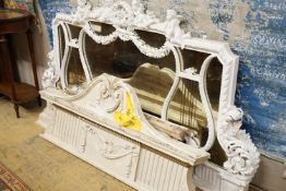 An Edwardian carved wood and gesso overmantel with cherub surmount, later painted white, width