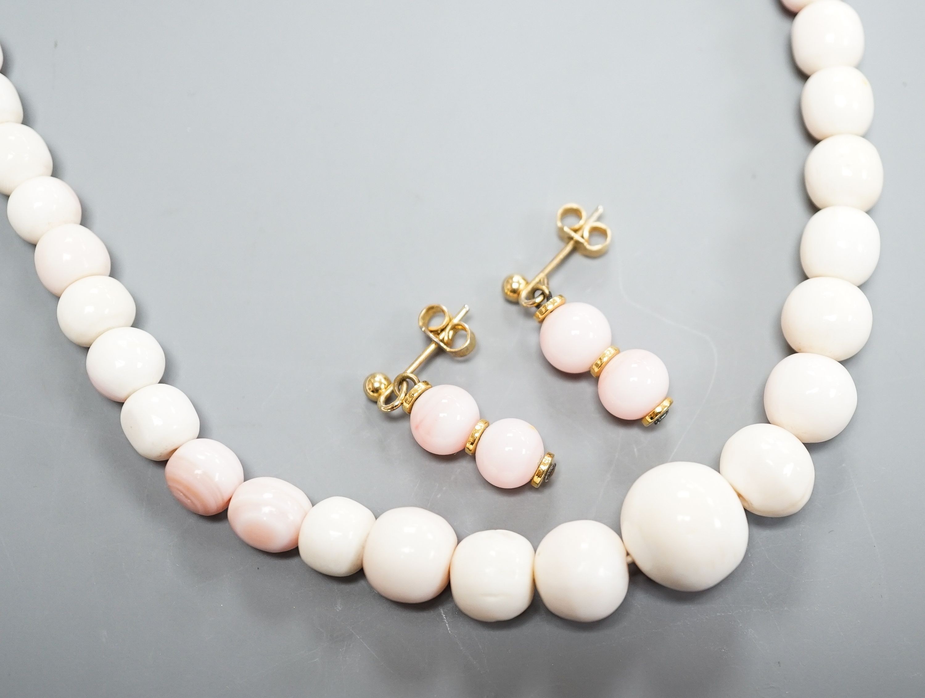 A single strand graduated bleached coral bead necklace, 51cm, gross 43.5 grams and a pair of 750