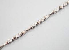 A modern 750 white metal and sixteen stone diamond set line bracelet, 19.2cm, gross weight 12.9