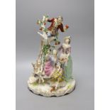 A large German porcelain group of figures picking fruit from a tree, 37cm