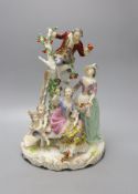 A large German porcelain group of figures picking fruit from a tree, 37cm