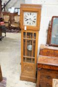 A 1930's chiming longcase clock, square silvered Roman dial in carved and panelled oak case,