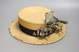 A straw boater, with crested badge and ribbon printed with ‘Alexandra’, 32 cms front to back