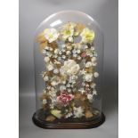 A late 19th century model of porcelain flowers under a glass dome 52cm total height