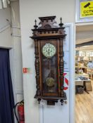 A late 19th century Austrian walnut wall clock, with key and pendulum, height 118cm