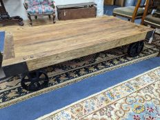 An Indian hardwood "door" table, on cast iron wheels, width 161cm, height 81cm