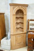 An 18th century style carved pine standing corner cupboard with arched shelved recess, width 94cm,