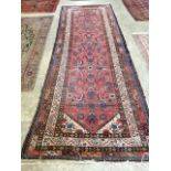 A Persian red ground runner, with central floral motifs, multi-bordered 330 x 123cm