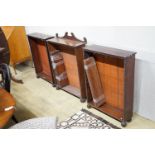 A set of three Regency mahogany open bookcases with beaded borders and fluted bun feet, one with