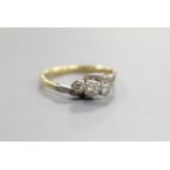 An 18ct, plat and three stone diamond crossover ring, size O, gross 2.4 grams.