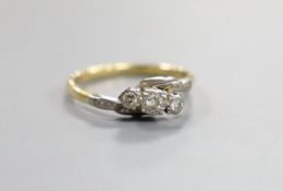 An 18ct, plat and three stone diamond crossover ring, size O, gross 2.4 grams.