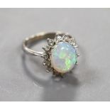 An 18ct white metal, white opal and diamond set oval cluster ring, size G, gross weight 2.9 grams.